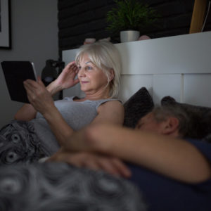 woman on tablet in bed