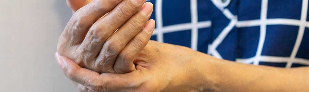 Photo of person rubbing hands arthritis.